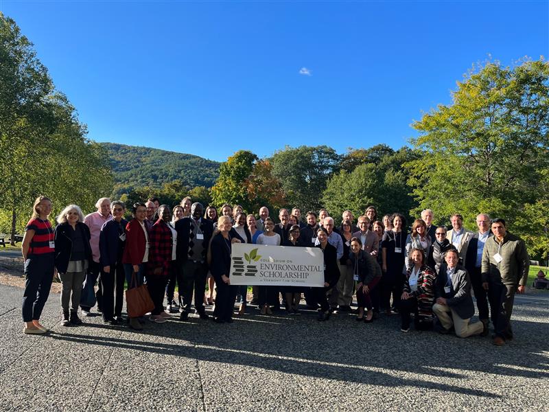 Group of people outside; group of people in the middle are holding a sign that says in large letters "Environmental Scholarship."